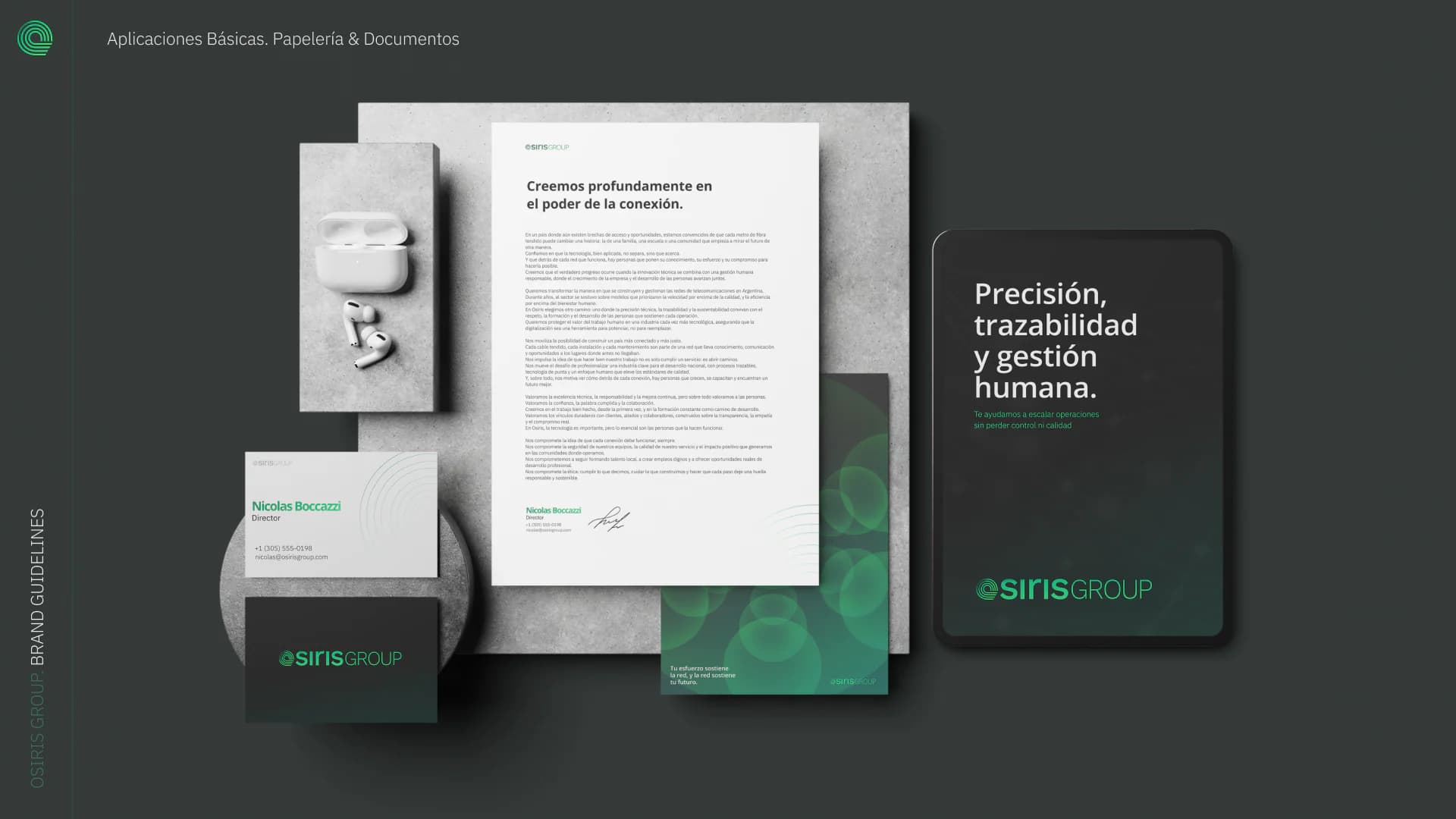 Stationery on a dark surface: letterhead, business cards, envelopes and a folder.