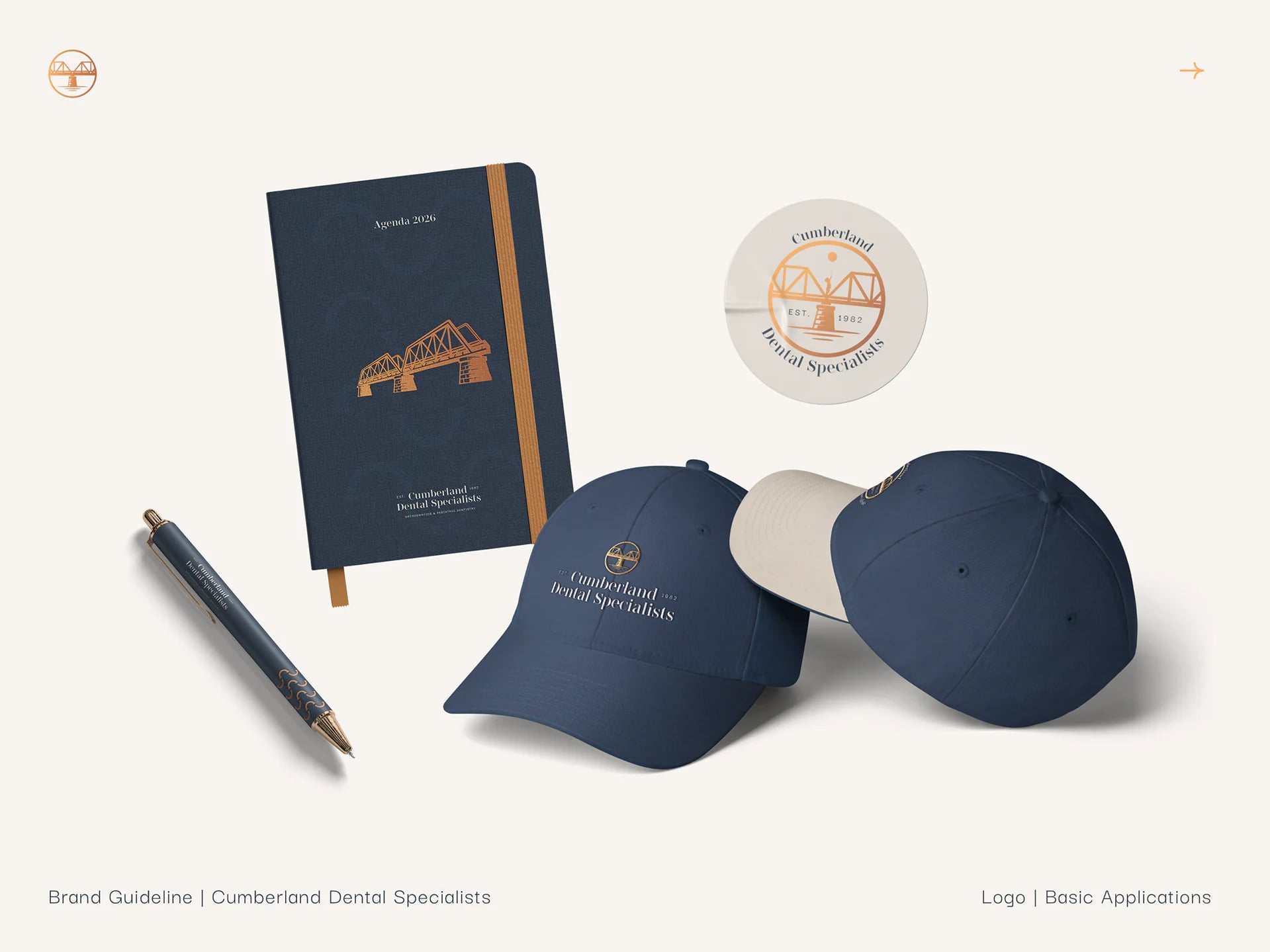 A navy notebook with the bridge, caps, a pen and a round seal.