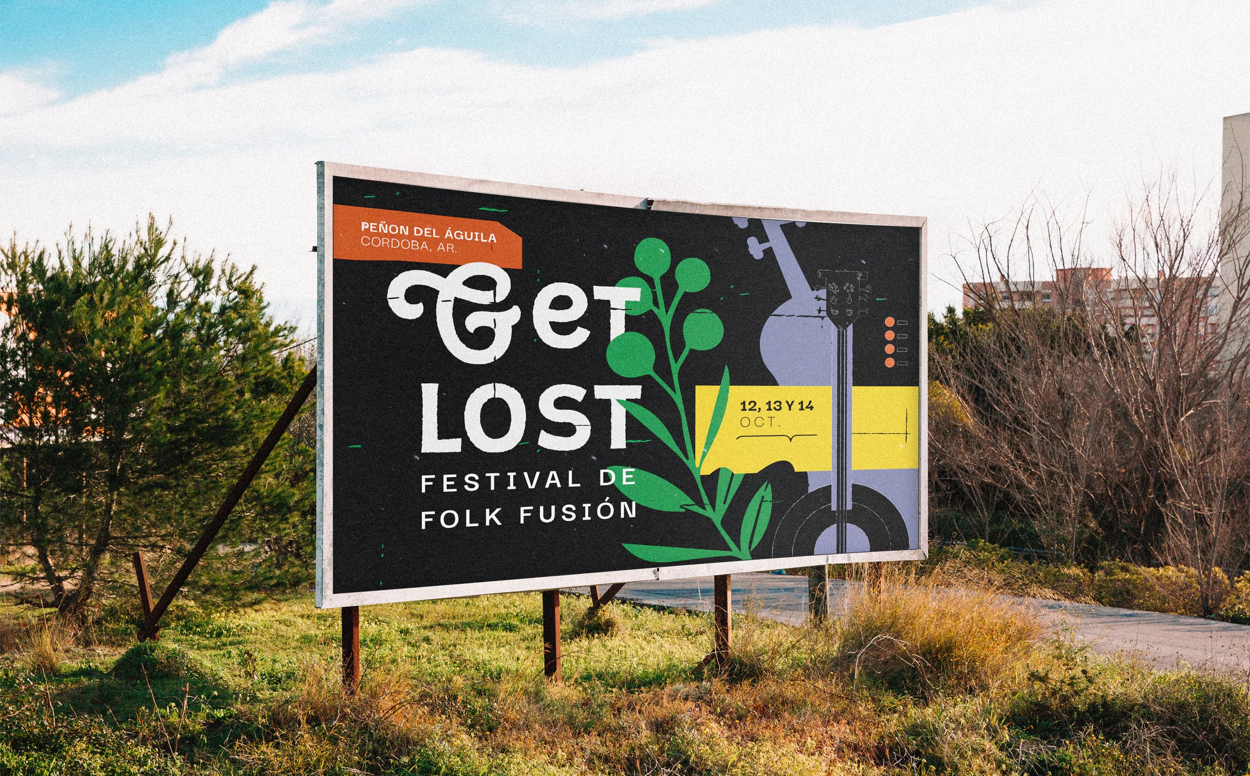 A Get Lost billboard standing in a field of grass and trees under a blue sky.