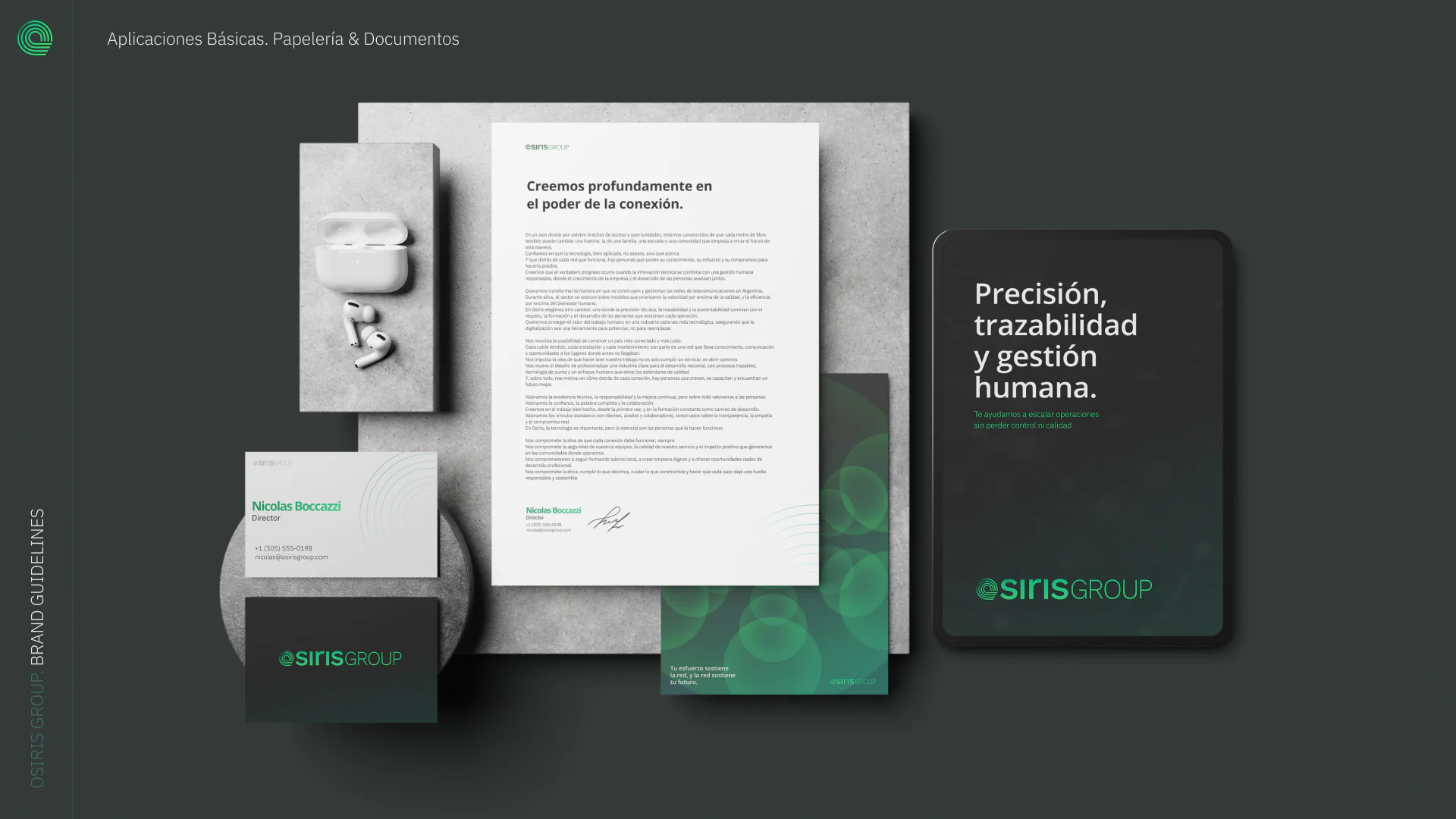 Stationery on a dark surface: letterhead, business cards, envelopes and a folder.